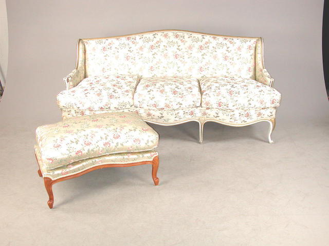 A 20th century Louis XVI style salon suite, comprising a white and gold painted sofa, a rectangular stool and two armchairs the sofa...