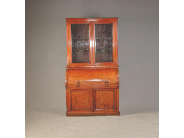 A Victorian mahogany cylinder bureau bookcase, with glazed doors revealing ajustable shelves, the cylinda enclosing drawers, pigeion...