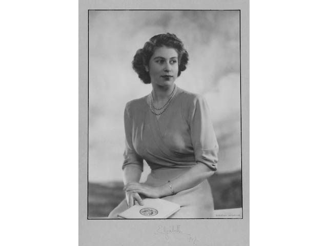 Dorothy Wilding, portrait photograph of Princess Elizabeth showing her seated and holding book, signed Elizabeth 1947. Framed and glazed with slight foxing to mount (image 294 x 208mm).