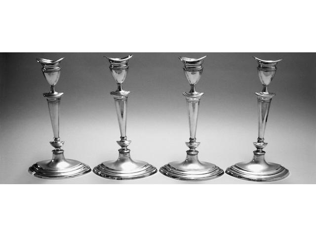 A set of four Edwardian silver candlesticks