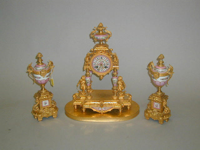 A French porcelain and gilt metal mounted three piece clock garniture,