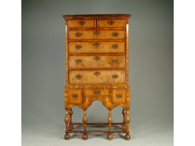 A walnut tallboy fitted with nine drawers