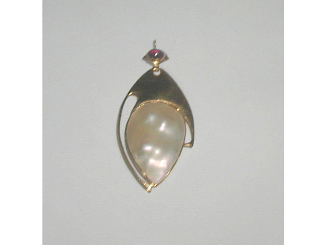 A mother of pearl and garnet pendant retailed by Liberty & Co to a design by Archibald Knox,