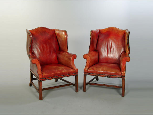 A pair of George III style mahogany framed wing back armchairs