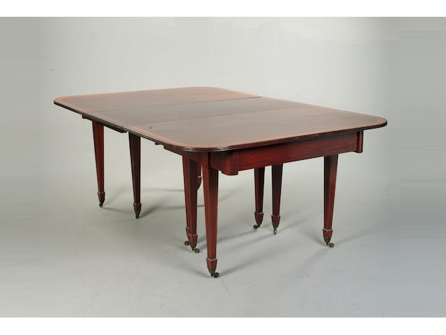 An Edwardian mahogany and satinwood banded extending dining table