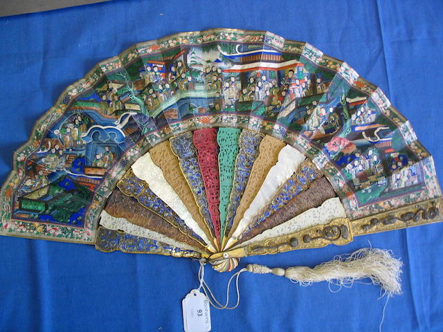 A good early 19th Century Chinese export fan The guards in gilded metal overlaid with silver wirework dragons and motifs, the sticks in alternating materials, gilded metal, ivory tortoiseshell, sandalwood and mother-of-pearl, some colour stained, the leaves painted to each side with numerous ivory faced courtiers arranged in terraces, on bridges and other defined areas within a floral, bird, fish and animal border, 29cm.