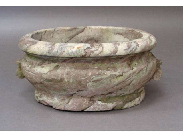 An 18th Century or earlier weathered and variegated rouge marble oval cistern