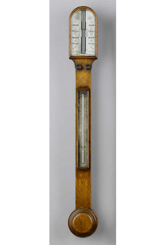 A late 19th Century oak stick barometer, Carpenter & Westley, 24 Regent St. London, arched hood over a slim trunk with twin recording knobs, mercury thermometer and flat fronted turned cistern cover, twin ivory angled dials with verniers, 93cms high.