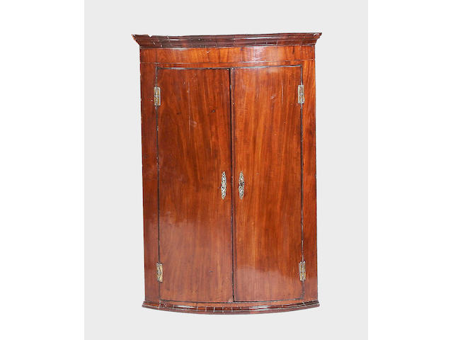 A George III mahogany bow-fronted hanging corner cupboard,