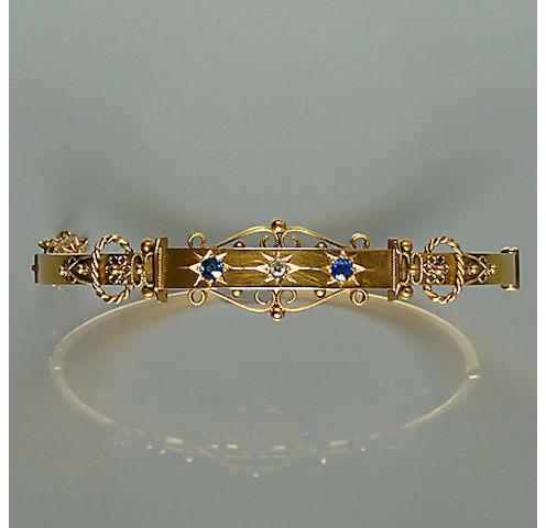 50302240001 An early 20th century diamond and sapphire-set 15ct. gold bangle