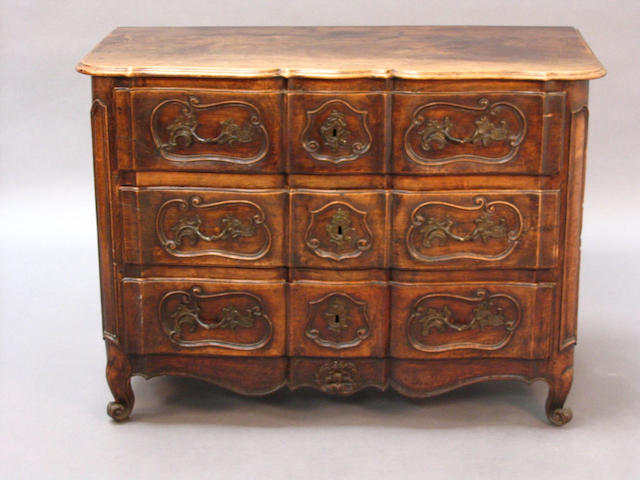 An 18th century French provincial walnut commode of shaped outline