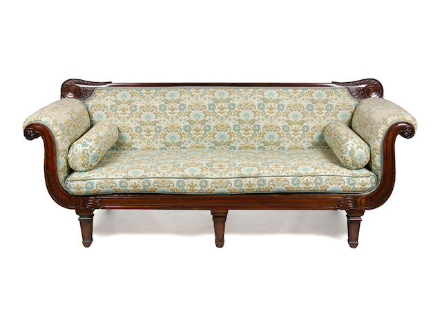 A pair of William IV carved mahogany three seater sofas
