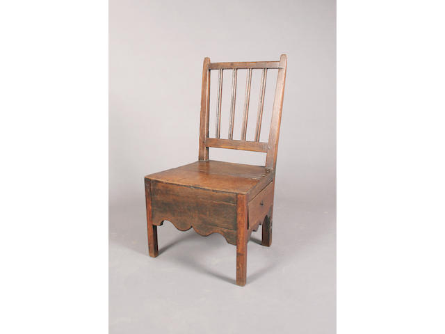 A late 18th century oak low standard chair,