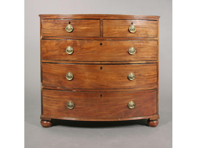 An early 19th century mahogany bow front chest of two short and three long graduated drawers,