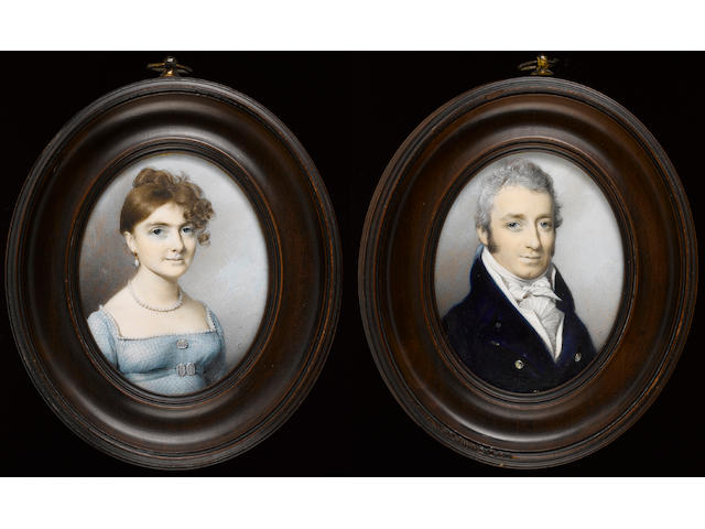 George Engleheart, A pair of portraits of a Lady and Gentleman; she wearing pale blue checked dress with white trim, blue belt with pearl buckle matching pearl brooch, necklace and drop earring, her hair upswept and falling over her face; he wearing dark blue coat, white waistcoat, frilled white chemise and tied cravat
