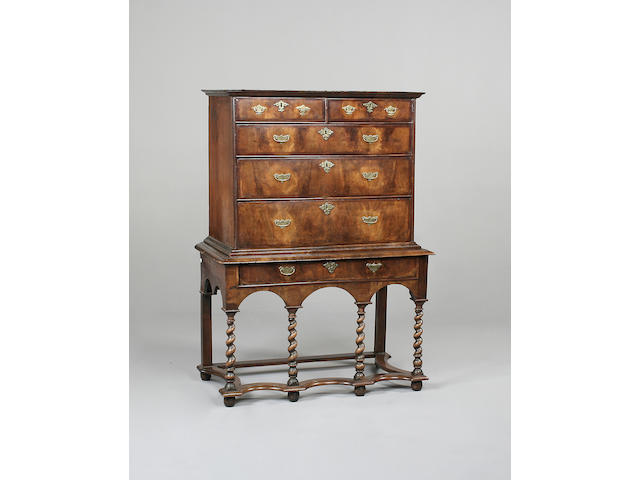 An early 18th century walnut chest on later stand