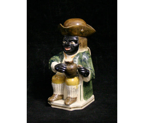An unusual Pratt type 'black man' Toby jug and replacement cover, circa 1820-30