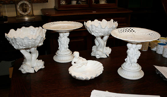 A pair of blanc de chine comports, formed with shell shaped bowls supported by three mythical sea beasts, another pair of comports with figural columns (one a/f), and a blanc de chine shell shaped dish with figural surmount