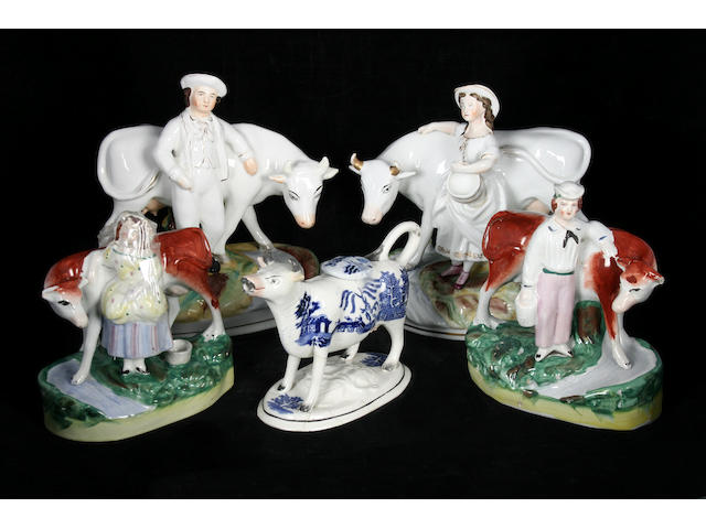 Two pairs of Staffordshire cow groups and a cow creamer