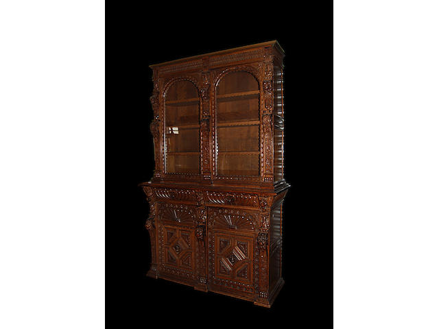 A Victorian carved oak glazed bookcase on cupboard