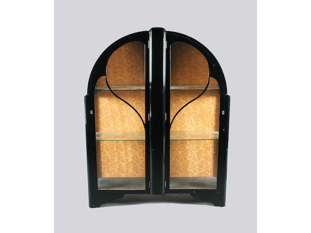 An Art Deco black finish china cabinet of arched form