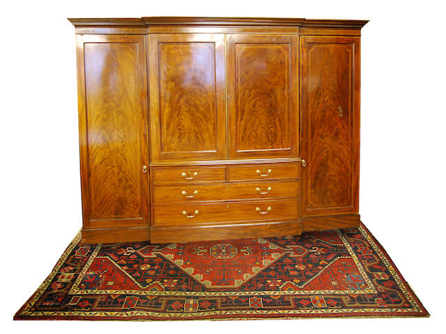 A large figured mahogany and inlaid breakfront clothes press, early 19th Century