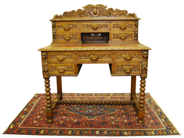A late Victorian carved oak writing table