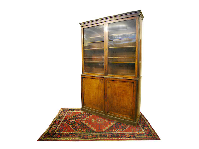 A large George IV mahogany and ebony-strung bookcase on cupboard