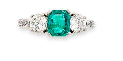 An emerald and diamond three-stone ring