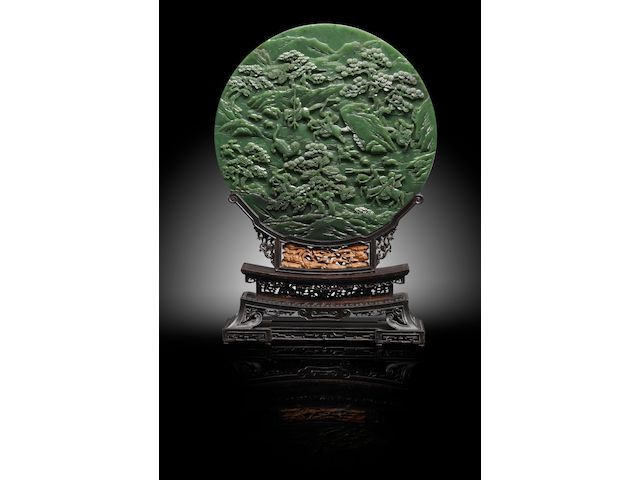 An Imperial spinach green jade 'tiger hunt' circular screen Qianlong