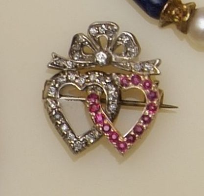 A diamond and ruby double heart brooch