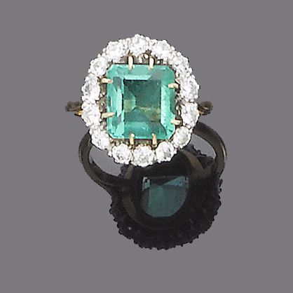 An emerald and diamond cluster ring