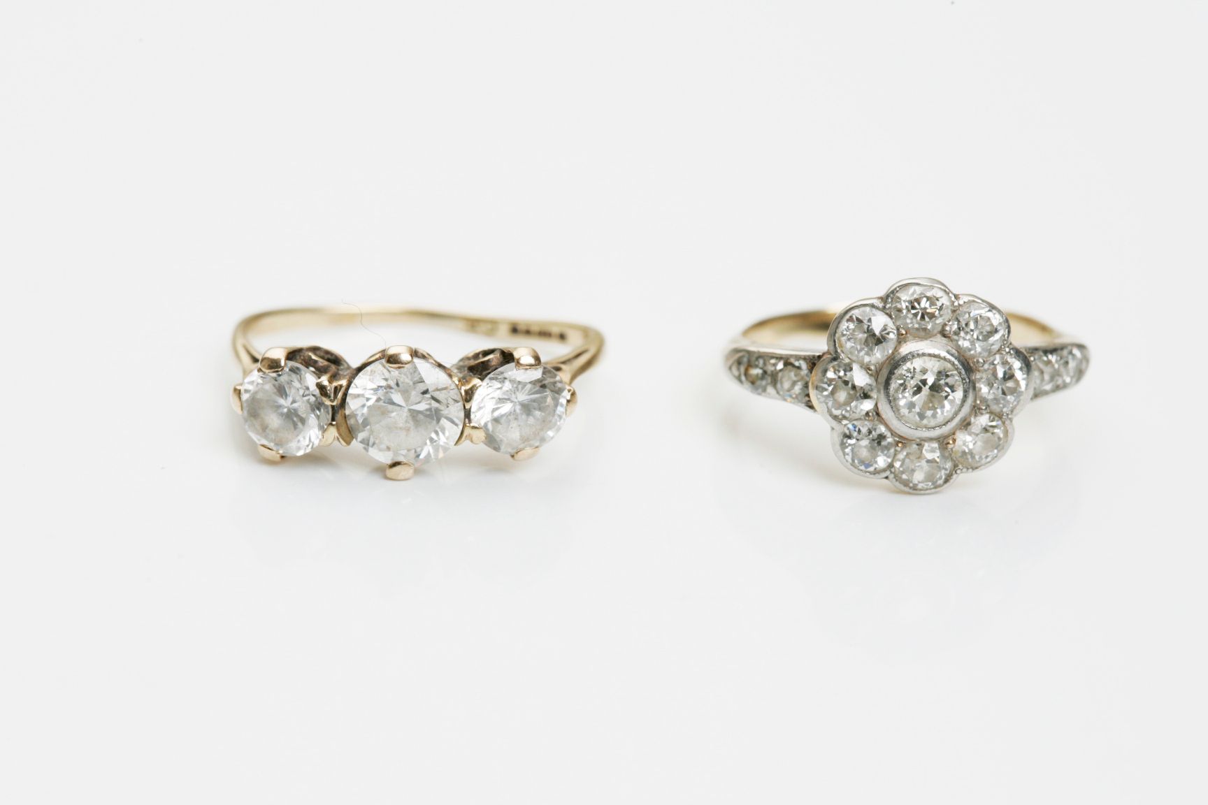 A diamond cluster ring together with a paste three-stone ring