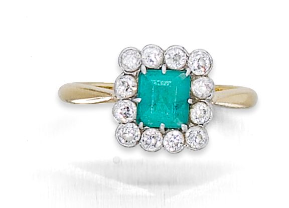 An emerald and diamond cluster ring