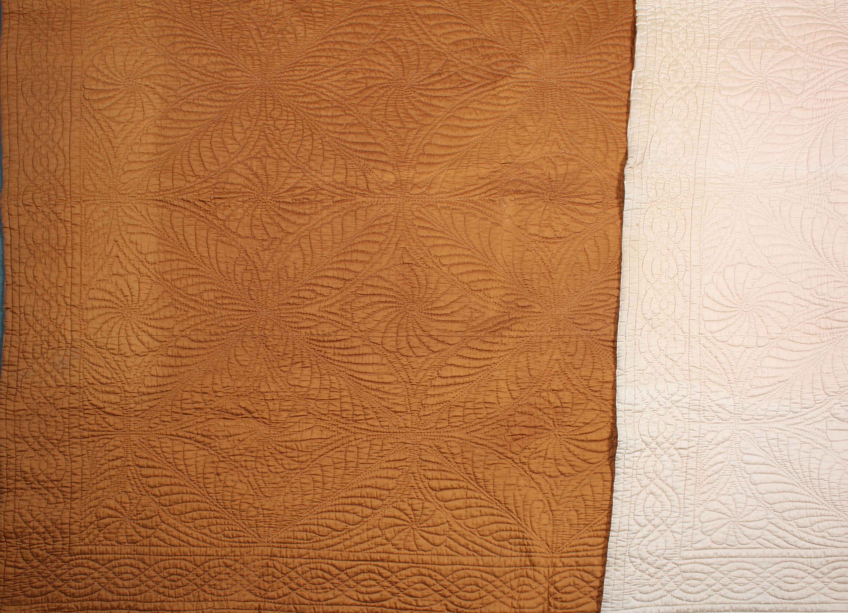 A Durham quilt of canary yellow reversing to bright orange quilted with