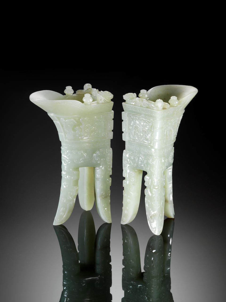 An important and rare pair of archaistic pale celadon jade wine vessels, jue Incised Qianlong four-c