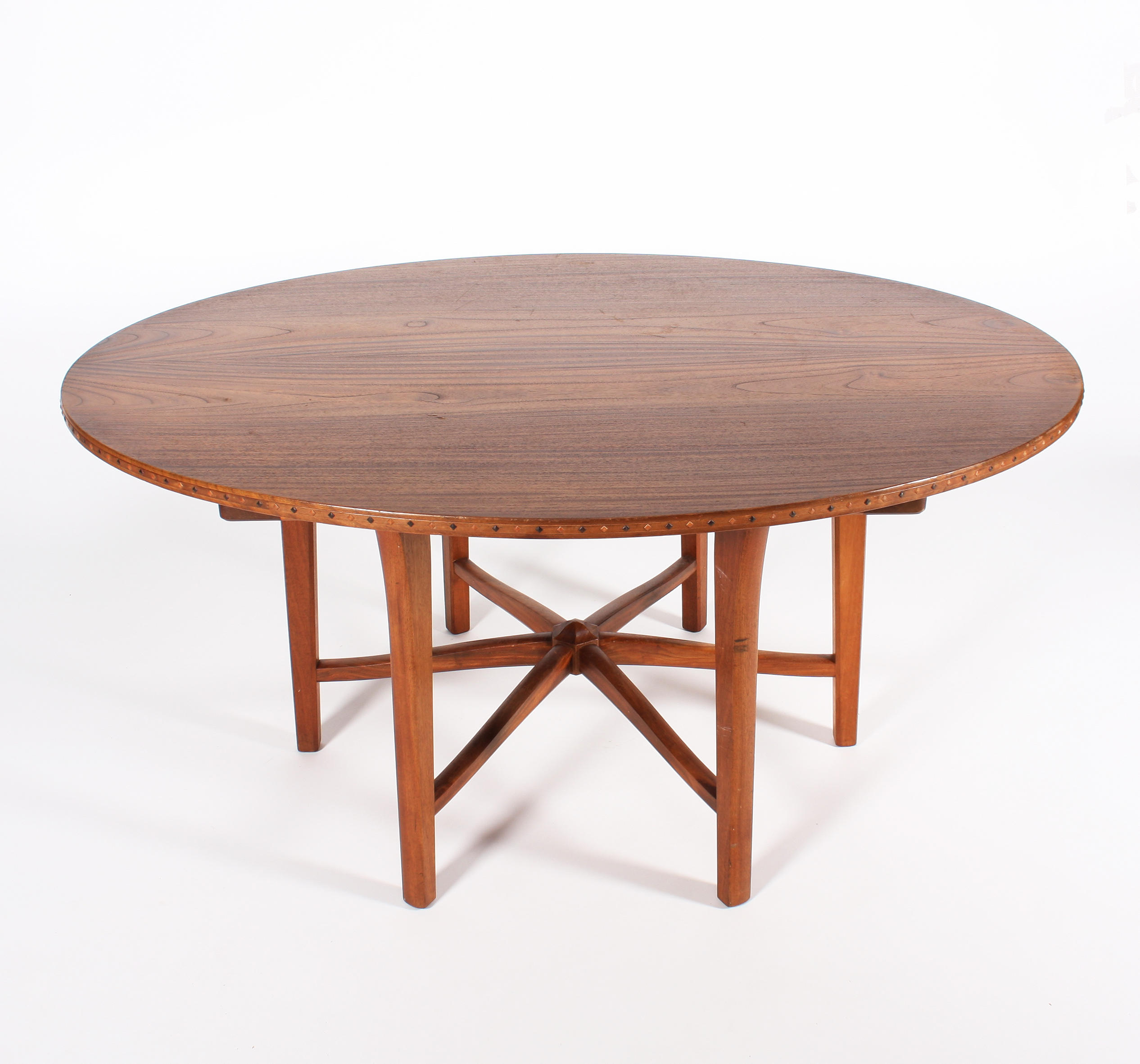 A mahogany dining table in the style of Hugh Birkett