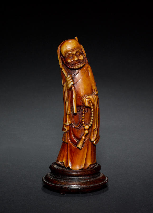 Bonhams : An ivory or bone figure of a standing luohan, holding a ...