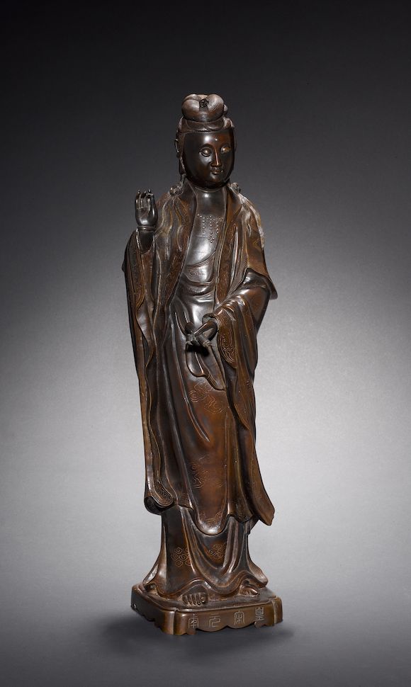 Bonhams A bronze statue of Guanyin, holding a scroll with the left