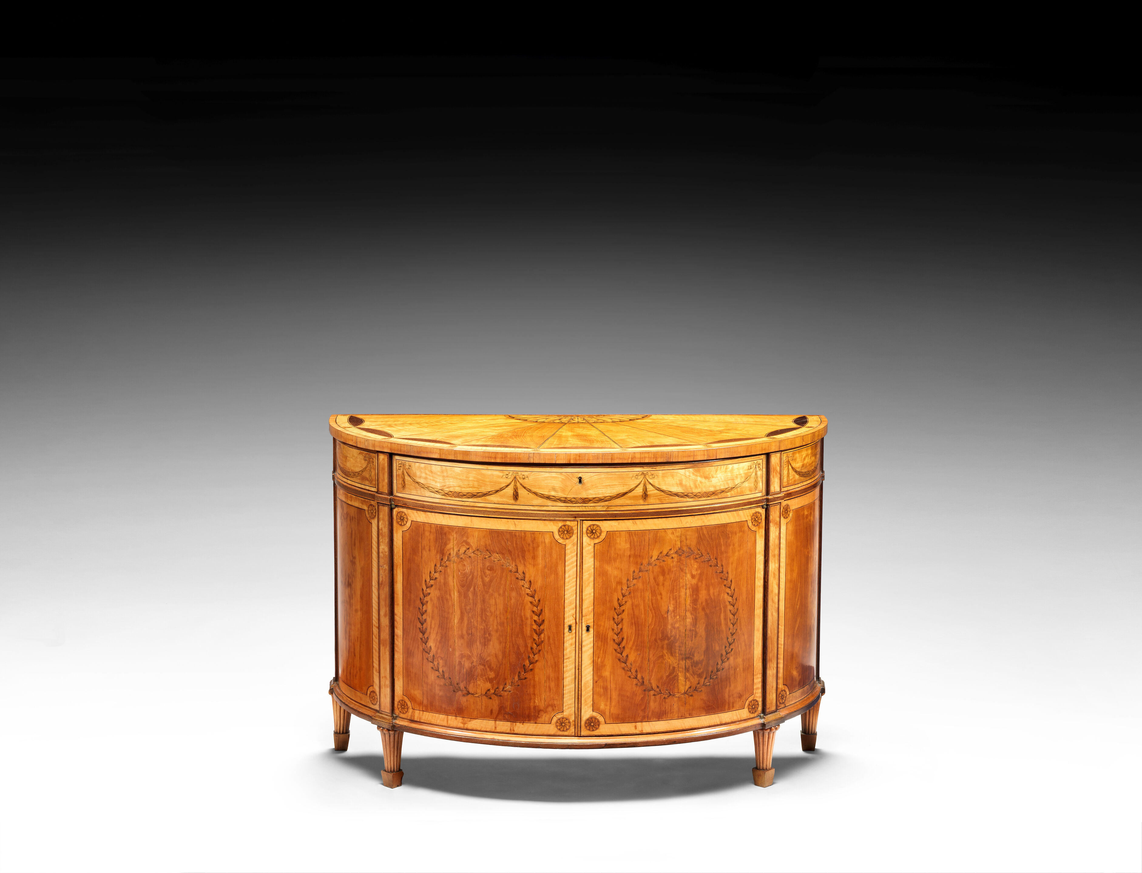 A George III satinwood, amaranth, tulipwood and marquetry demi-l