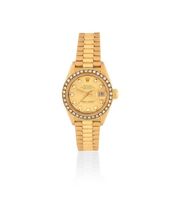 Bonhams Rolex. A lady's 18K gold and diamond set automatic calendar