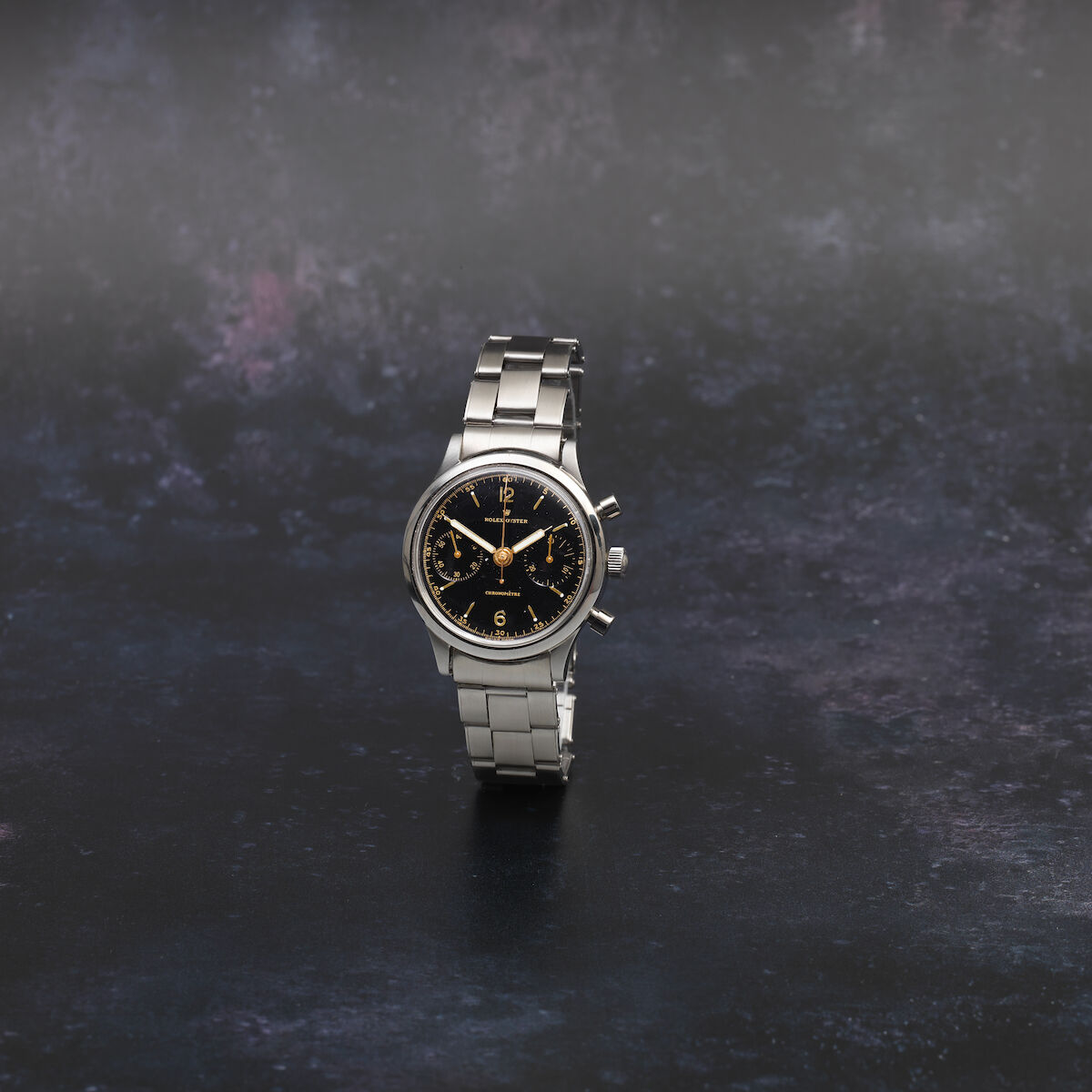 Steel 3525 of circa 1940 on a bracelet: black gloss dial with only a gilt 1/5-second track at the edge and no tachymeter or telemeter, registers at three and nine. · Photo: Bonhams · © Bonhams, used with permission · Source: https://www.bonhams.com/auction/26684/lot/11/rolex-a-stainless-steel-manual-wind-chronograph-bracelet-watch-oyster-monoblocco-ref-3525-circa-1940/