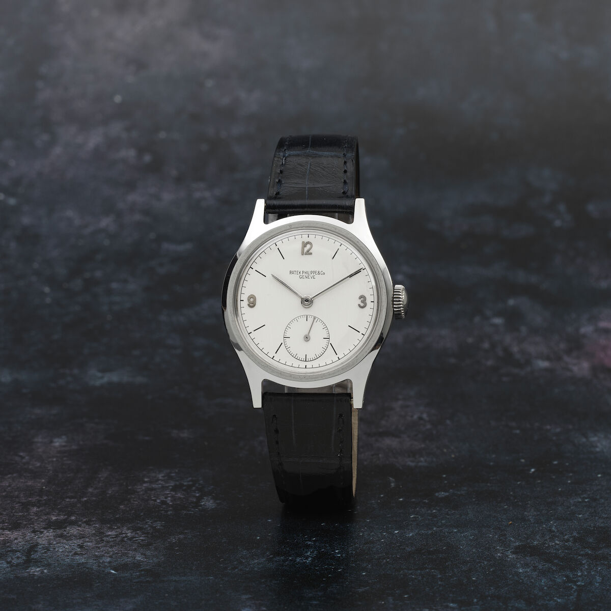 Stainless-steel 565 made in 1944 (cal. 12-120) with white dial, black batons and applied Arabic quarter numerals, small seconds; screw-down back case by François Borgel. · Photo: Bonhams · © Bonhams, used with permission · Source: https://www.bonhams.com/auction/26687/lot/21/patek-philippe-a-fine-and-rare-stainless-steel-manual-wind-wristwatch-calatrava-ref-565-manufactured-1944-purchased-19th-february-1945/