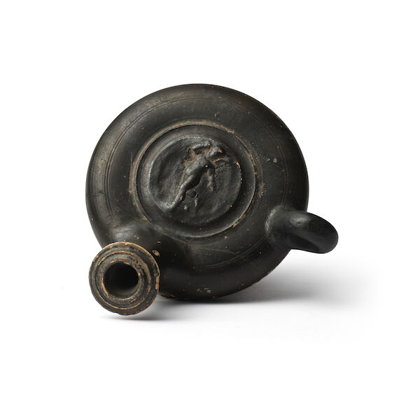 Bonhams : A Greek Calene ware black glazed guttus