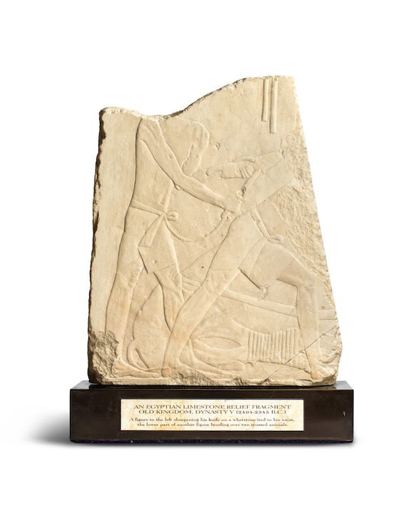 Bonhams : An Egyptian limestone relief fragment with a butchery scene