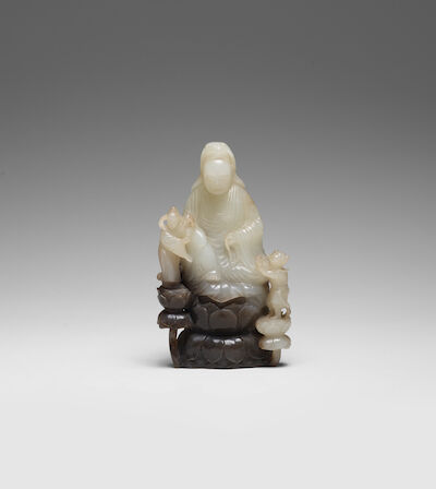 A RARE WHITE AND CHESTNUT JADE CARVING OF GUANYIN AND ATTENDANTS Qianlong/Jiaqing