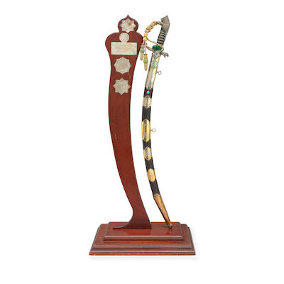 An unusual gem-set enamelled silver-gilt hilted steel ceremonial sword commemorating the family of the Shaykhs of the Al al-'Abid, the leaders of the Albu Diraj clan in Iraq, with the names of three of its recent leaders London, 20th Century, the hilt hallmarked 1995(2)
