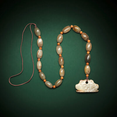 A STRAND OF OVOID JADE BEADS AND A JADE BEAST-MASK PENDANT Neolithic Period and later