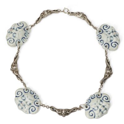 Arje Griegst: "The cheeky kids" A necklace of sterling silver decorated with porcelain faces. L. 45 cm.