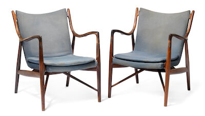 Finn Juhl: "FJ 45". A pair of Brazilian rosewood easy chairs. Made and stamped by cabinetmaker Niels Vodder. (2) "FJ 45". A pair of Brazilian rosewood easy chairs. Sides, back and loose seat cushion upholstered with blue wool, blue leather edgings. Designed 1945. Made and stamped by cabinetmaker Nie